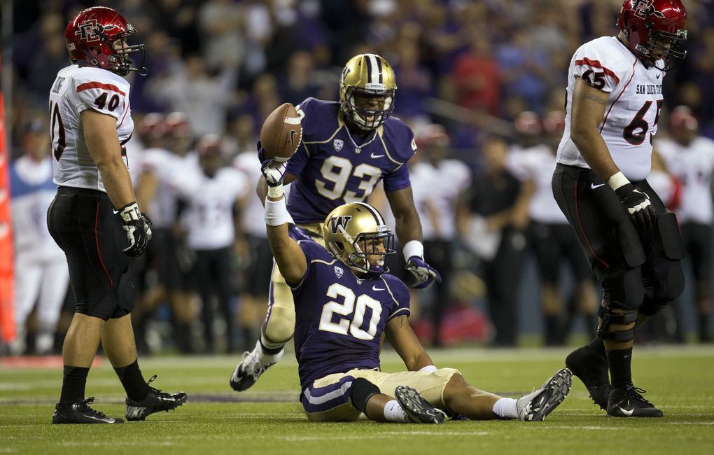 Washington’s Justin Glenn recovers a fumble that San Diego State quarterback Ryan Katz lost during a game in 2012. (Seattle Times file)
