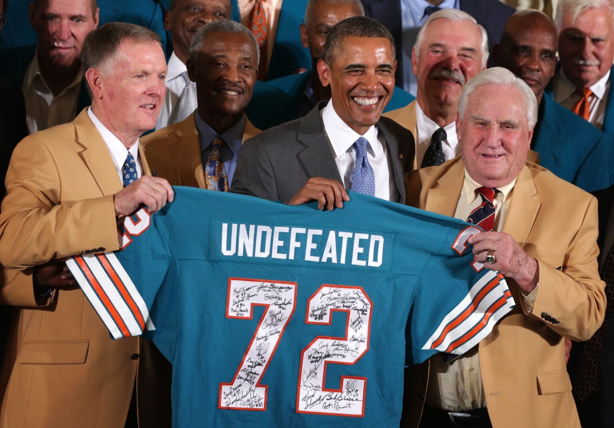 President Barack Obama (L) receives a commemorative jersey from hall of  fame coach Don Shula (R) as Obama honors Super Bowl VII Champion Miami  Dolphins and their perfect season, during a ceremony