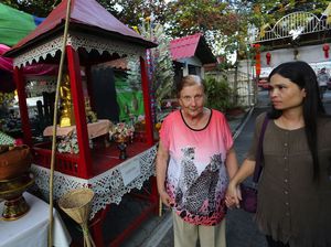  Margrit, left, an Alzheimer&rsquo;s patient from Switzerland, walks with a caretaker during a tour at a Buddhist temple in Chiang Mai province, Thailand. Thailand is poised to attract more Alzheimer&rsquo;s sufferers from abroad, offering   centers with 24-hour personal care that&rsquo;s cheaper than in the West. <br/>