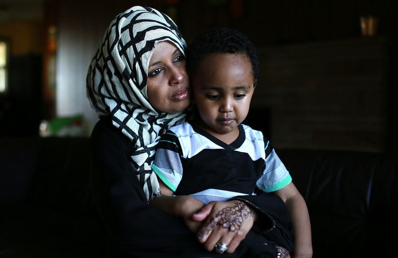 Kadija Hussein, 34, owner of a Tukwila day care, holds son Ayyub Osmond, 3, one of her four children. She and her husband, a Port of Seattle truck driver, send about $500 a month back to family in Somalia, helping keep relatives’ children in school, food on the table and roofs over their heads. “In Somalia, there are no jobs,” Hussein said. (ERIKA SCHULTZ/THE SEATTLE TIMES )
