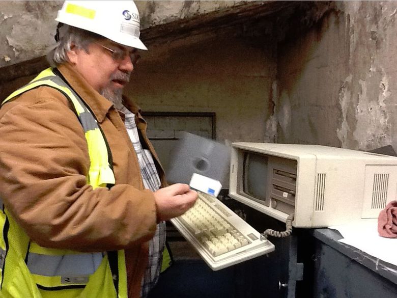 Old-school software: Deep in the north control tower, Larry Finnick brandishes a floppy disc. (Photo by Mike Lindblom / The Seattle Times)