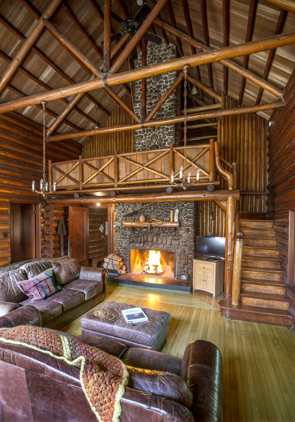 Polished wood beams, a wood floor and classic river-rock fireplace set the tone at the 100-year-old Copper Creek Lodge, rented out by Copper Creek Inn. It can sleep 12. (Steve Ringman/The Seattle Times)