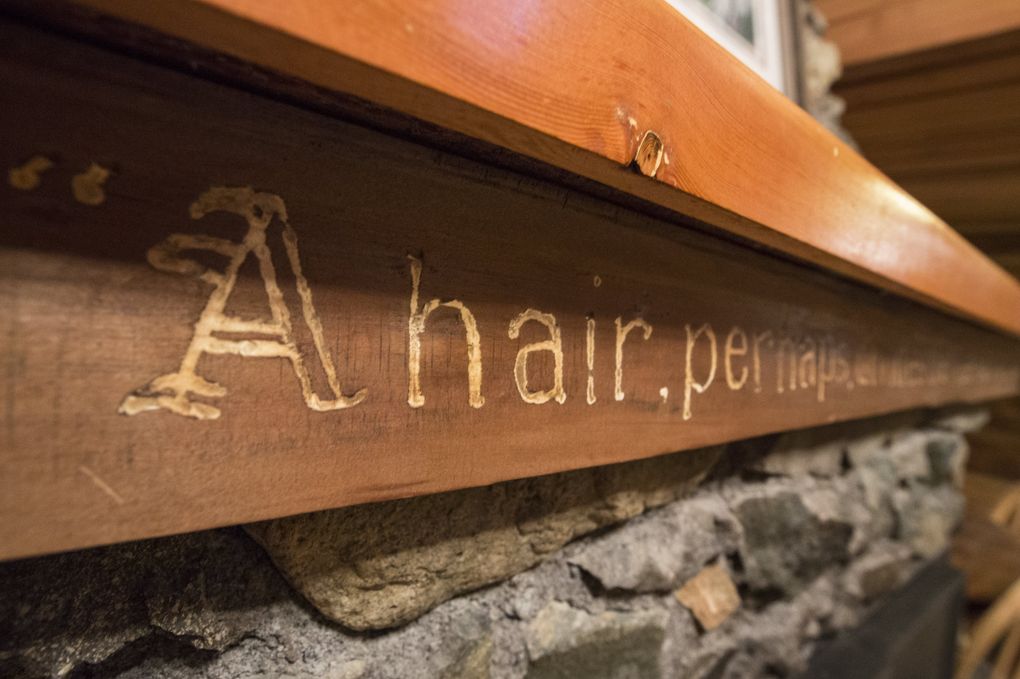 Carved above the fireplace in the Mountain Home Log Cabin is a quote by 11th-century philosopher Omar Khayym. It reads, “A hair, perhaps, divides the false and true.” (Steve Ringman/The Seattle Times)