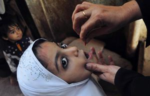 epa04667327 A health worker administers the polio vaccine to a child in Karachi, Pakistan, 18 March 2015. According to reports two female polio workers and one of their police escorts were killed 17 March when two unidentified gunmen opened fire on them while they administered vaccines in an Afghan refugee camp in north-western Pakistan, while a bomb hidden in a toy killed three, including two children, in the same region.  EPA/SHAHZAIB AKBER KAR03