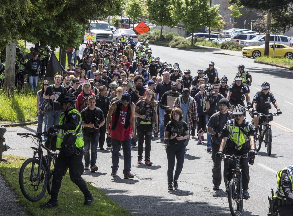 Seattle Police escort a small group from the “Black Lives Matter” rally as they walk up Martin Luther King Jr. Way South on their way to another rally and march at Judkins Park. (Steve Ringman / The Seattle Times)