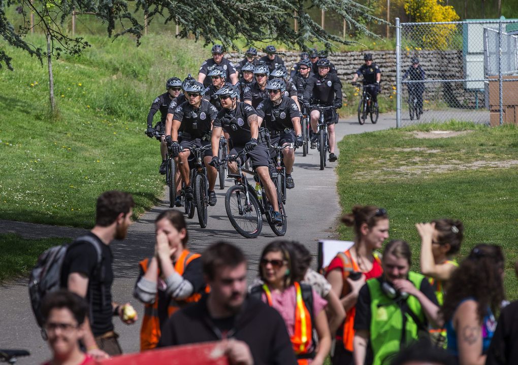 Police escorting a May Day march arrive at Judkins Park. (Dean Rutz / The Seattle Times)