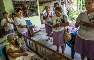 Missionaries pray for Carmen Ayala Lopez, 80, in San Salvador, El Salvador, May 22, 2015. The women are followers of Salvadoran Archbishop Oscar Romero, who was murdered in 1980 and beatified in a ceremony Saturday in San Salvador, leaving him one step from sainthood. (Meridith Kohut/The New York Times)
