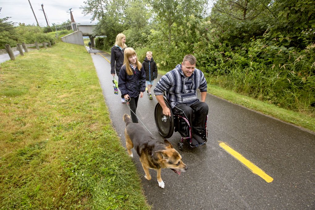 Barry Long, of Woodinville, navigates the Sammamish River trail with his children, twins Grace and Gavin, his wife, Emily, and their dog Sitka, near the Redhook Brewery. The path is among wheelchair-friendly trails around Puget Sound. (Steve Ringman/The Seattle Times)