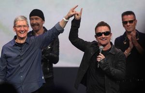 Apple CEO Tim Cook connects fingers with Bono to symbolically launch the release of U2’s new album on Apple’s iTunes during an Apple product release event at the Flint Center in Cupertino, Calif., on Tuesday, Sept. 9, 2014. (Karl Mondon/Bay Area News Group/TNS) 1168183