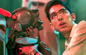 Deon (Dev Patel) boots up Chappie (Sharlto Copley) in Columbia Pictures’ action-adventure film “Chappie.” (Photo courtesy Sony Pictures/TNS)