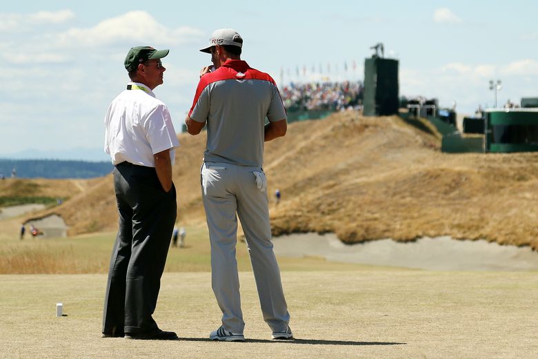 Dustin Johnson (right) chats with USGA executive director Mike Davis during the third round of the 115th U.S. Open at Chambers Bay. (Mike Ehrmann/Getty Images)