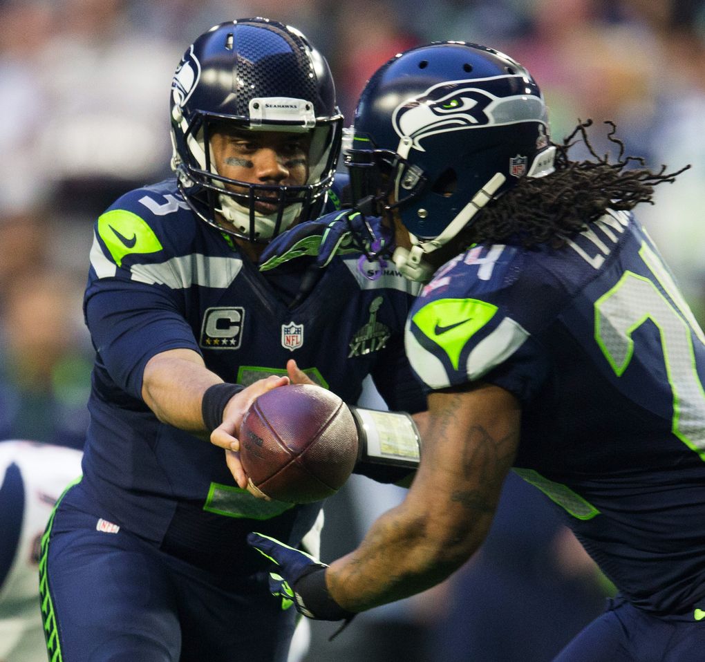 Russell Wilson hands off to Seahawks running back Marshawn Lynch, then Lynch rushes for four yards during the first quarter as the Seattle Seahawks take on the New England Patriots in Super Bowl XLIX. (Dean Rutz / The Seattle Times)