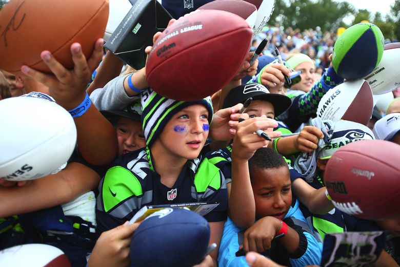 Kids vie to get the autograph of Seahawks quarterback Russell Wilson during training camp. (John Lok / The Seattle Times)