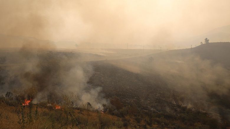Hillsides smolder after wildfire swept through the Chelan area. (Sy Bean / The Seattle Times)