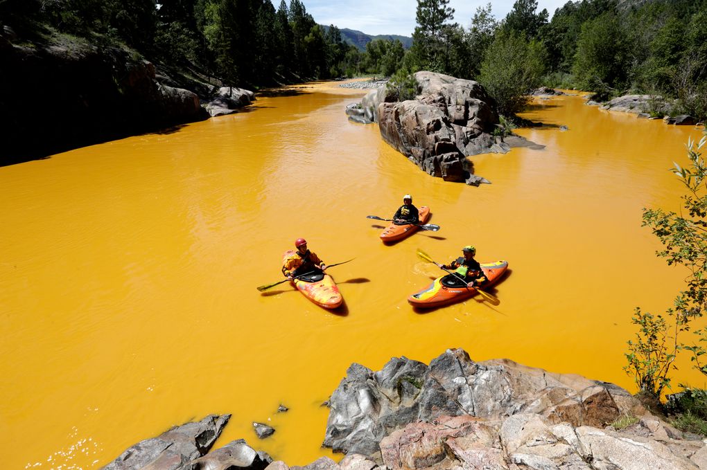 FILE – In this Thursday, Aug. 6, 2015 file photo, people kayak in the Animas River near Durango, Colo., in water colored yellow from a mine waste spill. A crew supervised by the U.S. Environmental Protection Agency has been blamed for causing the spill while attempting to clean up the area near the abandoned Gold King Mine. Tribal officials with the Navajo Nation declared an emergency on Monday, Aug. 10, as the massive plume of contaminated wastewater flowed down the San Juan River toward Lake Powell in Utah, which supplies much of the water to the Southwest. (Jerry McBride/The Durango Herald via AP)