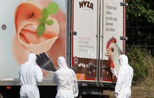 Investigators stand near  a  truck that  stands on the shoulder of the highway A4 near Parndorf south of Vienna, Austria, Thursday, Aug 27, 2015. At least 20 migrants were found dead in the truck parked on the Austrian highway leading from the Hungarian border, police said. (AP Photo/Ronald Zak)