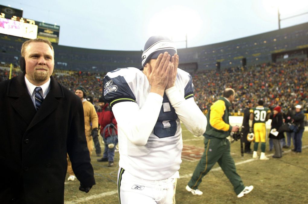Matt Hasselbeck covers his face as he walks off the turf at Lambeau Field following Seattle’s 33-27 overtime loss to Green Bay. (Rod Mar / The Seattle Times)