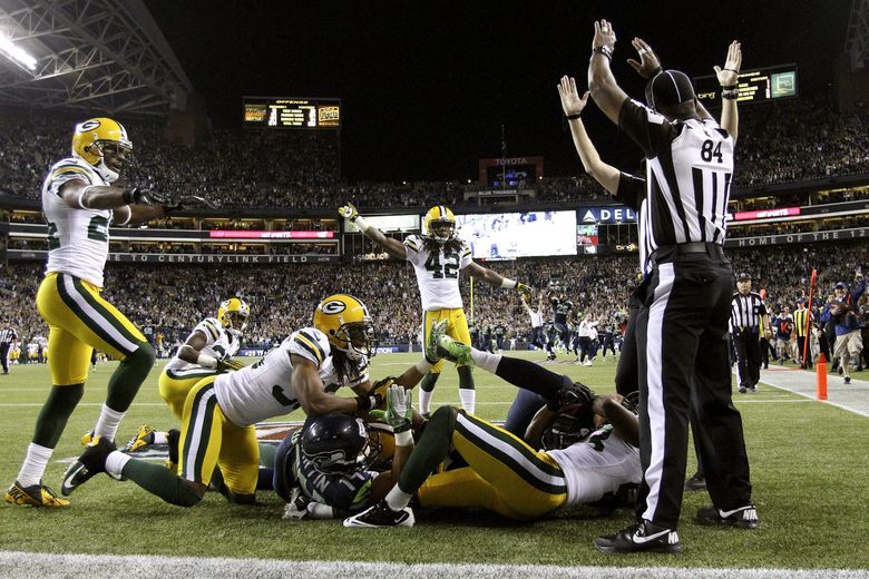 Officials signal a touchdown after Seattle Seahawks wide receiver Golden Tate pulled in a last-second pass from quarterback Russell Wilson to defeat the Green Bay Packers 14-12 in an NFL football game, Monday, Sept. 24, 2012, in Seattle. (AP Photo/The Seattle Times, John Lok)