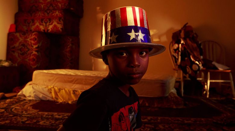 Ibrahim Shire, 7, wears an American-flag hat after his first Fourth of July living in the United States. After growing up in a refugee camp in Eritrea, he immigrated with his widowed mother and siblings to the Seattle area, but his family has struggled to pay rent. (Erika Schultz / The Seattle Times)