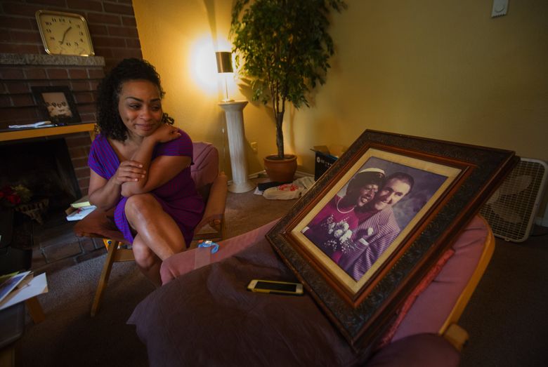 Tiffany Prinos admires her parents’ wedding photo in her mother’s SeaTac apartment. Her mother died recently, and Prinos came from her home in Missouri to pack up her mom’s belongings. (Ellen M. Banner/The Seattle Times)