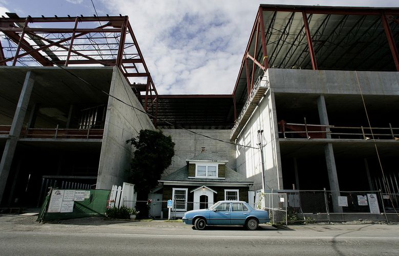 Edith Macefield&#8217;s old Chevy Cavalier is parked in front of her tiny Ballard house as development engulfed her small home in June 2008. (Alan Berner/The Seattle Times)