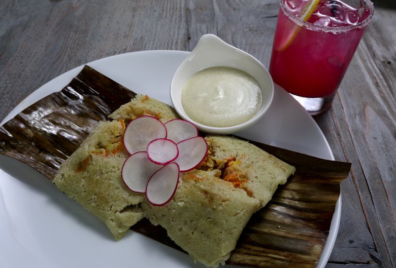 A tamale with langoustine and crabmeat tucked into fluffy masa. Chavez steams his tamales in banana leaves rather than corn husks. The drink is a La Estefania, with reposado tequila, St. Germain, fresh lemon and prickly pear. (Greg Gilbert/The Seattle Times)