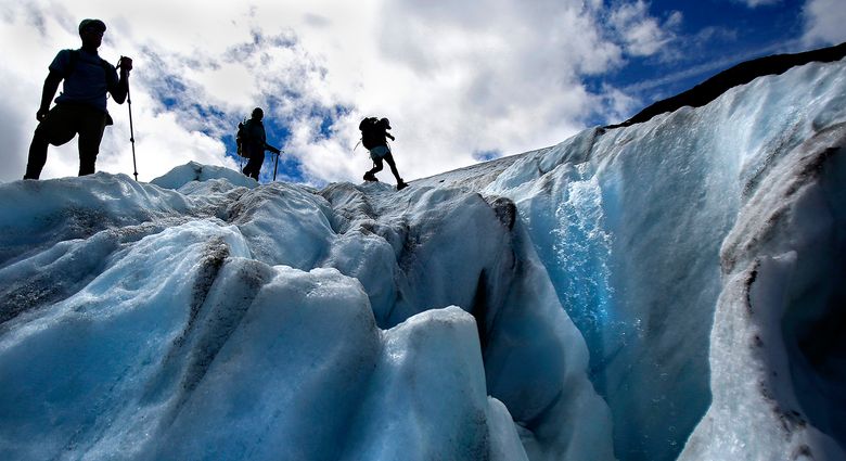 Research assistants navigate around a supraglacial stream on Sholes Glacier as they make measurements Friday, Aug. 7, 2015, to assess the volume lost. The findings will be added to the 32 years of data recorded by glaciologist Mauri Pelto. Sholes Glacier, which is on the northeast slopes of Mount Baker, has receded more than 90 meters, or nearly 300 feet, Pelto said. (Sy Bean / The Seattle Times)