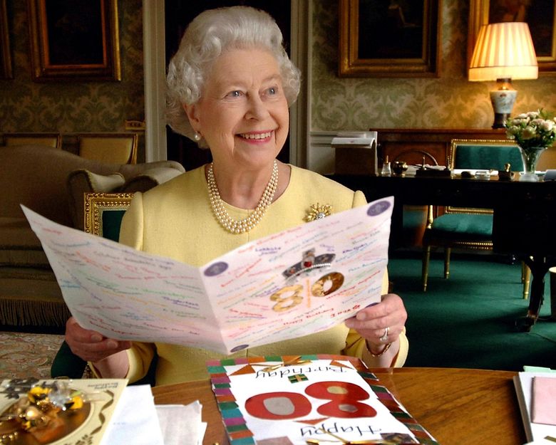 FILE – This is a April 20, 2006  file photo of Queen Elizabeth II sitting in the Regency Room at Buckingham Palace in London looking at some of the cards which have been sent to her for her 80th birthday. (Fiona Hanson/PA, File via AP) UNITED KINGDOM OUT