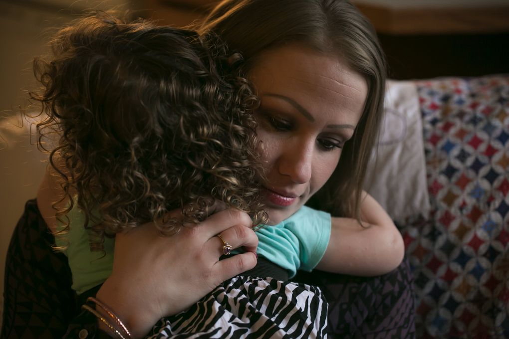 Dana Disharoon hugs one of her three daughters; they were living in temporary housing in Magnuson Park. (Bettina Hansen / The Seattle Times)