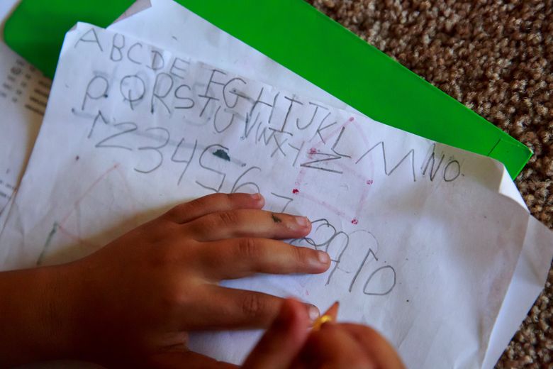 Fenet Zeleke, 6, of Ethiopia, practices writing the English alphabet and numbers shortly after moving with her family from a Mary’s Place shelter in Seattle to a townhome. (Erika Schultz/The Seattle Times)