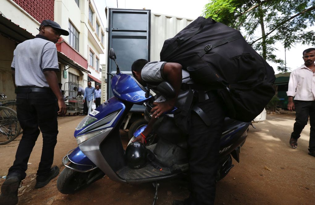 Massive backpacks filled with Amazon boxes are taken by scooter and motorcycle drivers early in the day to avoid the crush of Bangalore’s traffic jams. (Alan Berner / The Seattle Times)