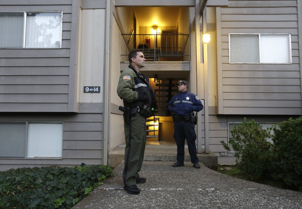 Douglas County Deputy Sheriff Greg Kennerly, left, and Oregon State Trooper Tom Willis, stand guard outside the apartment building, Friday, where alleged Umpqua Community College gunman Chris Harper Mercer lived, in Roseburg, Ore. Armed with multiple guns, Harper, 26, walked in a writing class at the community college, Thursday, and opened fire, killing several and wounding several others. (Rich Pedroncelli / The Associated Press)