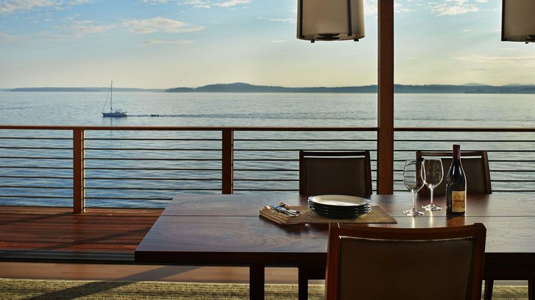 The dining room can be opened to the deck and the deep blue sea beyond. (Benjamin Benschneider/The Seattle Times)