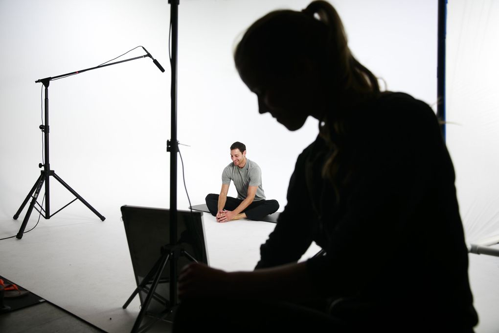 Daniel Segars, center, stretches before filming a workout with his wife, Kelli Segars, in the garage of their home north of Seattle. The couple started Fitness Blender, a popular online website offering workout videos, health plans and recipes. (Erika Schultz/The Seattle Times)
