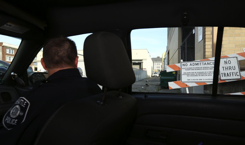 Seattle police check a barricade that is supposed to be blocking access to an alley where drug deals were taking place. (Ken Lambert/The Seattle Times)