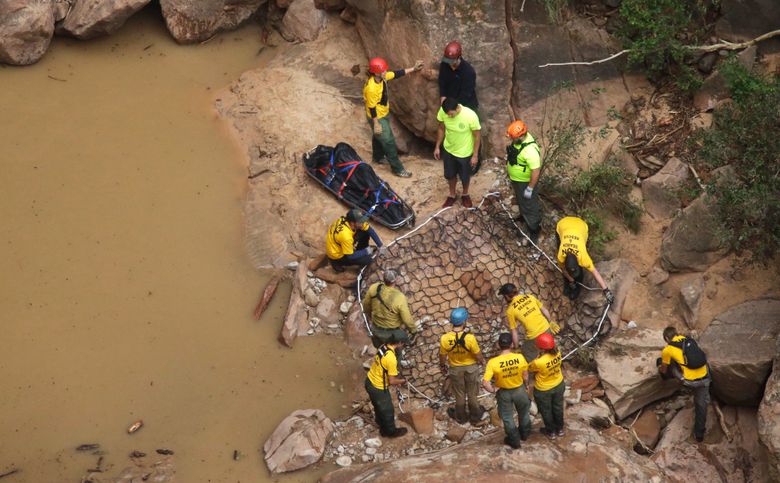 FILE – In this Sept. 16, 2015 file photo, search and rescue team members place a litter near a net for helicopter transport after finding a body in Pine Creek, in Zion National Park, near Springdale, Utah.  Zion National Park officials are retracing what led up to the deaths of seven people in a flooded canyonon Sept. 15 before a panel assesses what can be done to keep a growing number of visitors safe when spectacular natural settings turn perilous. (AP Photo/Rick Bowmer, File)