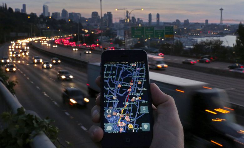 The transportation app Waze shows Interstate 5 in red, like the brake lights in the background of cars heading south through Seattle during a recent evening rush hour. Seattle is encouraging developers to think more creatively about the data at their fingertips. (Ken Lambert / The Seattle Times)