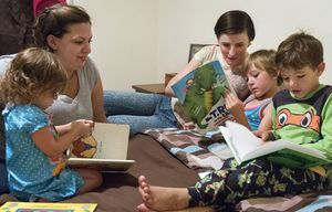 Reading stories out loud helps Jennifer Peace, left, and her spouse, Deborah, help get the children quieted down before bed. “Our kids are well-adjusted, they’re doing great,” Peace said. “Maybe people are finally willing to accept that not every family looks like the (classic) nuclear family.” Photo taken at their home in Spanaway on Aug. 28, 2015.
