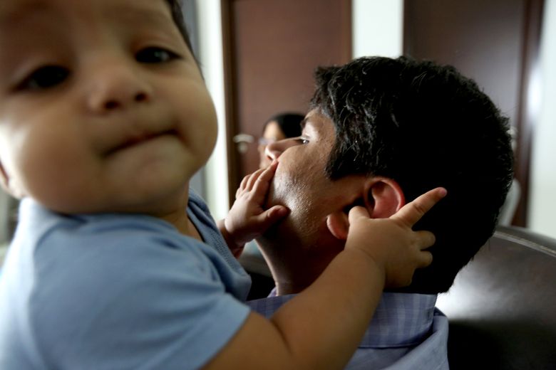 Rohan Shirwaikar, who lived on Queen Anne when he worked at Amazon’s headquarters in South Lake Union, relaxes with one of his twins, Tarun, at his home in Hyderabad. Shirwaikar, now a senior software development engineer at Amazon in Hyderabad, can have a cook, driver, maid and nanny for $600 a month.  (Alan Berner / The Seattle Times)