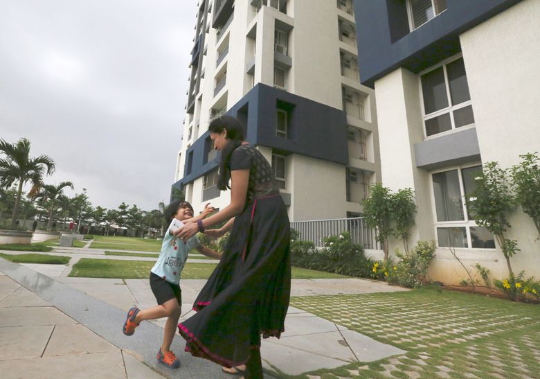 Ekta Maheshwari Kasat and daughter Anika play on the grounds of the condominium complex where they live in Hyderabad. Husband Nimish, an engineer, was employed at Amazon in Seattle for eight years before returning to India in 2012 to work for Amazon’s operations there. (Alan Berner / The Seattle Times)