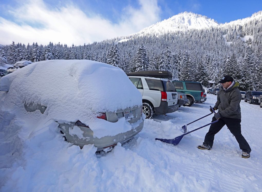 Tyler Meyers of Tacoma digs out his car at Crystal Mountain parking lot. Skiing has been tremendous this winter with lots of powder every day. (Steve Ringman / The Seattle Times)