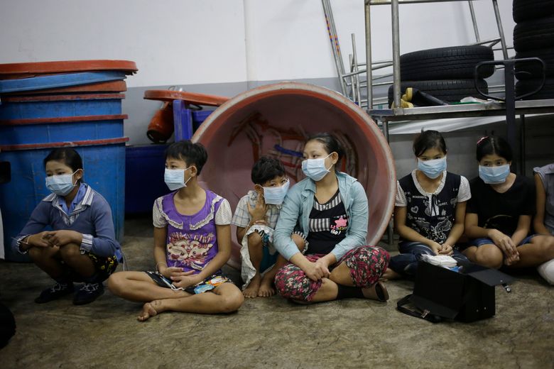 ADVANCE FOR USE MONDAY, DEC. 14, 2015 AT 12:01 A.M. EST (05:01 GMT) AND THEREAFTER – In this Monday, Nov. 9, 2015 photo, children and teenagers sit together to be registered by officials during a raid on a shrimp shed in Samut Sakhon, Thailand. Abuse is common in Samut Sakhon, which attracts workers from some of the world’s poorest countries, mostly from Myanmar. An International Labor Organization report estimated 10,000 migrant children aged 13 to 15 work in the city. Another U.N. agency study found nearly 60 percent of Burmese laborers toiling in its seafood processing industry were victims of forced labor. (AP Photo/Dita Alangkara)