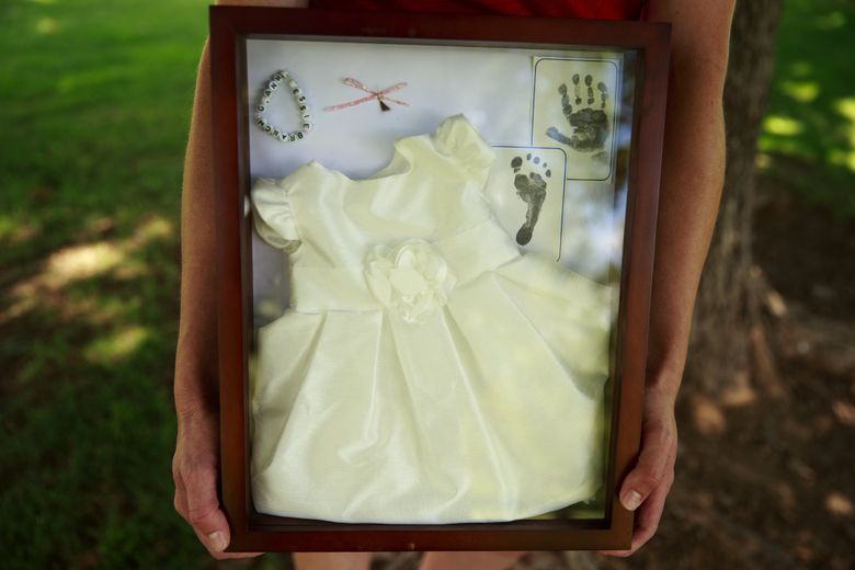The Branch family keeps mementos —  a bracelet, a dress, a snip of hair —  from their daughter Gianna’s short life. Steve Branch said he wishes the cluster were a “higher priority” for the state. (Erika Schultz / The Seattle Times)