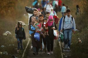 (IMAGE IS ONE OF 100 IN BEST OF 2015 PICTURE PACKAGE) SUBOTICA, SERBIA – SEPTEMBER 09:  Migrants make their way through Serbia, near the town of Subotica, towards a break in the steel and razor fence erected on the  border by the Hungarian government on September 9, 2015 in Subotica, Serbia. Thousands of migrants have funnelled their way across country to the small gap in the steel fence unopposed by the authorities.  Since the beginning of 2015 the number of migrants using the so-called ‘Balkans route’ has exploded with migrants arriving in Greece from Turkey and then travelling on through Macedonia and Serbia before entering the EU via Hungary. The number of people leaving their homes in war torn countries such as Syria, marks the largest migration of people since World War II.  (Photo by Christopher Furlong/Getty Images) 594617397