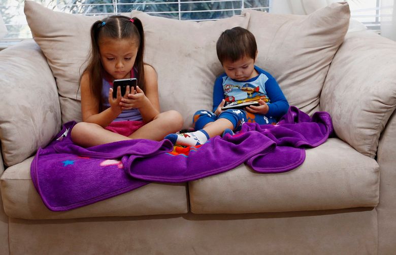 Juliana Sanchez, 5, and her brother, Francisco Sanchez Jr., 2, watch children’s programming on YouTube on their parent’s cell phones at their home on March 9, 2015 in Mountain House, Calif. Watching digital video on hand-held devices is the new normal for tots, tweens and teens. (Gary Reyes/Bay Area News Group/TNS)