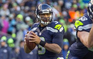 Seahawks quarterback Russell Wilson sets to pass as the Seattle Seahawks play the Cleveland Browns at CenturyLink Field December 20th, 2015. At left is Seahawks offensive lineman Patrick Lewis.