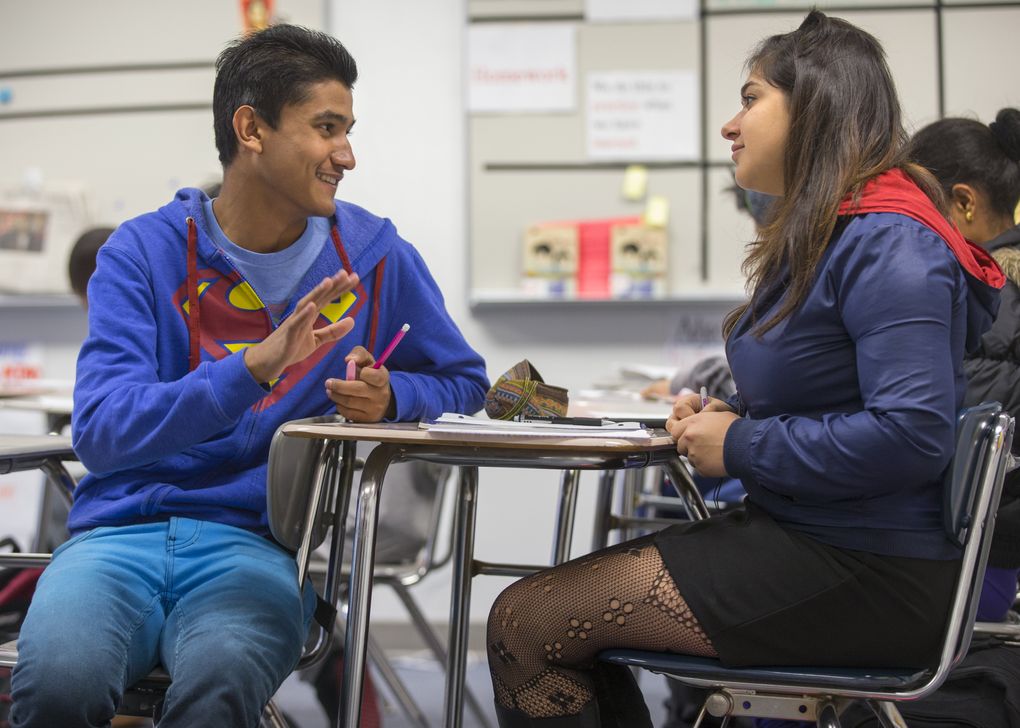 Students Jeewan Poudel, left, and Sama Jabbarimehmani converse during a recent class at Foster High School. Poudel, a junior. grew up in a refugee camp in Nepal. (Mike Siegel/The Seattle Times)