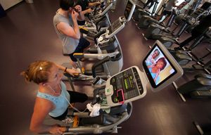 Rhiana Maidenberg listens to an audiobook on her iPhone while watching TV as she exercises at the Bakar Fitness and Recreation Center at the University of California San Francisco Mission Bay campus, in San Francisco, Aug. 6, 2010. Scientists say allowing the brain to have downtime can improve learning and memory and the ability to come up with new ideas. (Jim Wilson/The New York Times)