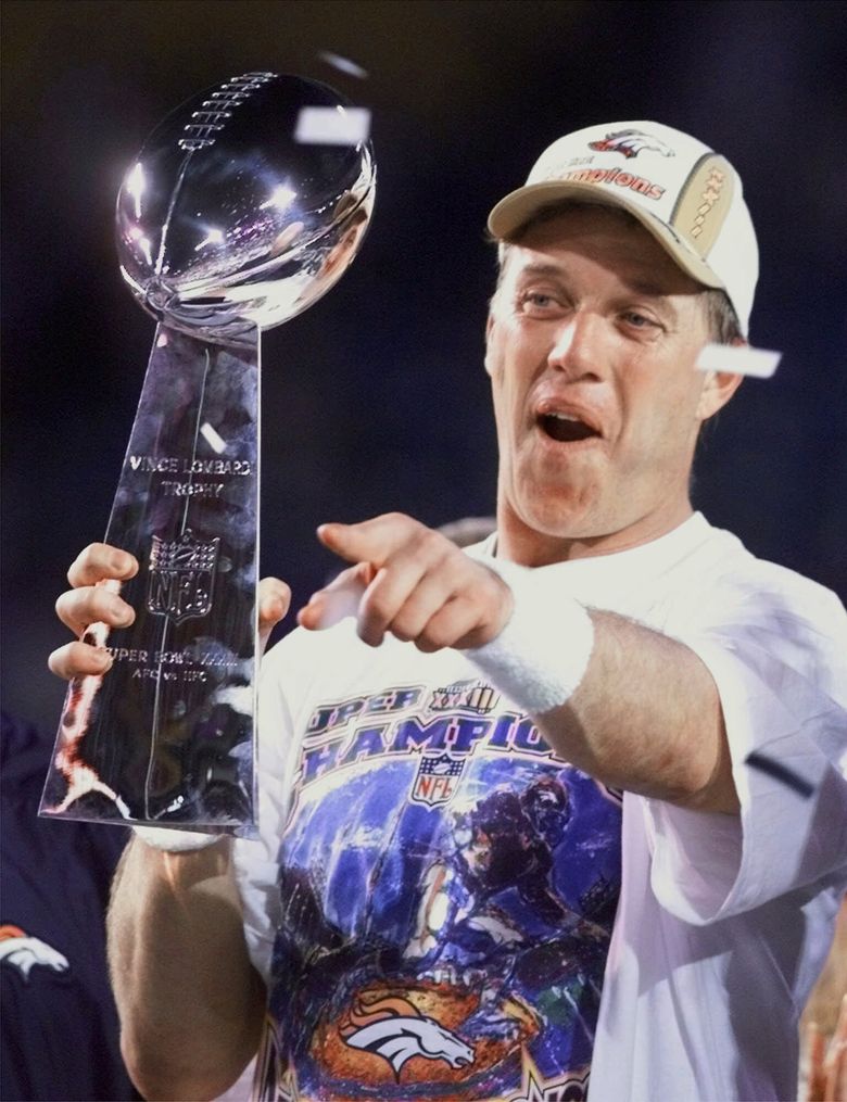 John Elway of the Denver Broncos holds up the Vince Lombardi