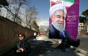 An Iranian woman walks past an electoral banner of President Hassan Rouhani who is a candidate of the Experts Assembly elections outside the former U.S. Embassy in downtown Tehran, Iran, Wednesday, Feb. 24, 2016. Iran’s parliamentary and Experts Assembly elections will take place on Feb. 26. (AP Photo/Vahid Salemi)